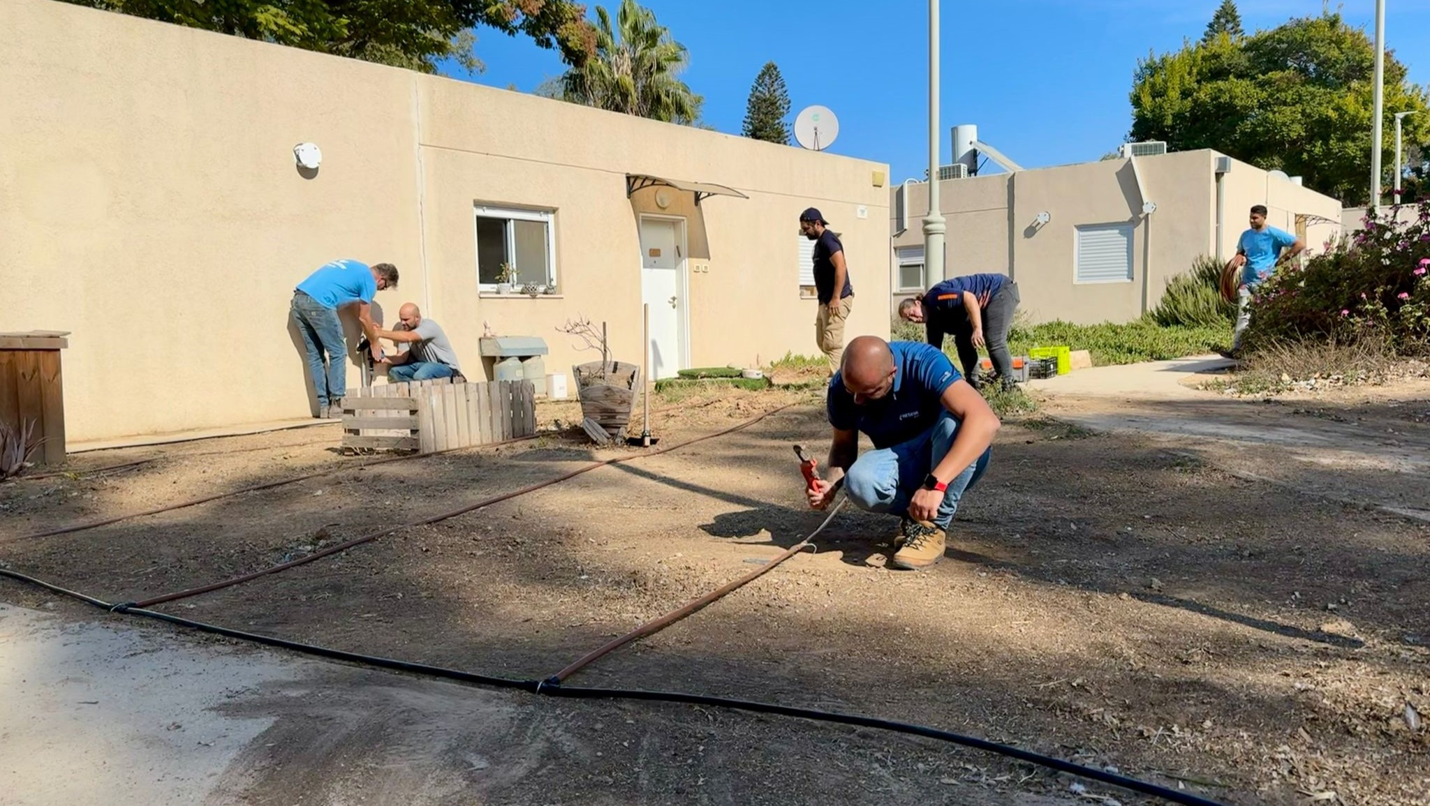 מחדשים את הגינות ליד הדירות ומתקינים טפטפות. עובדי נטפים השבוע בנחל עוז 