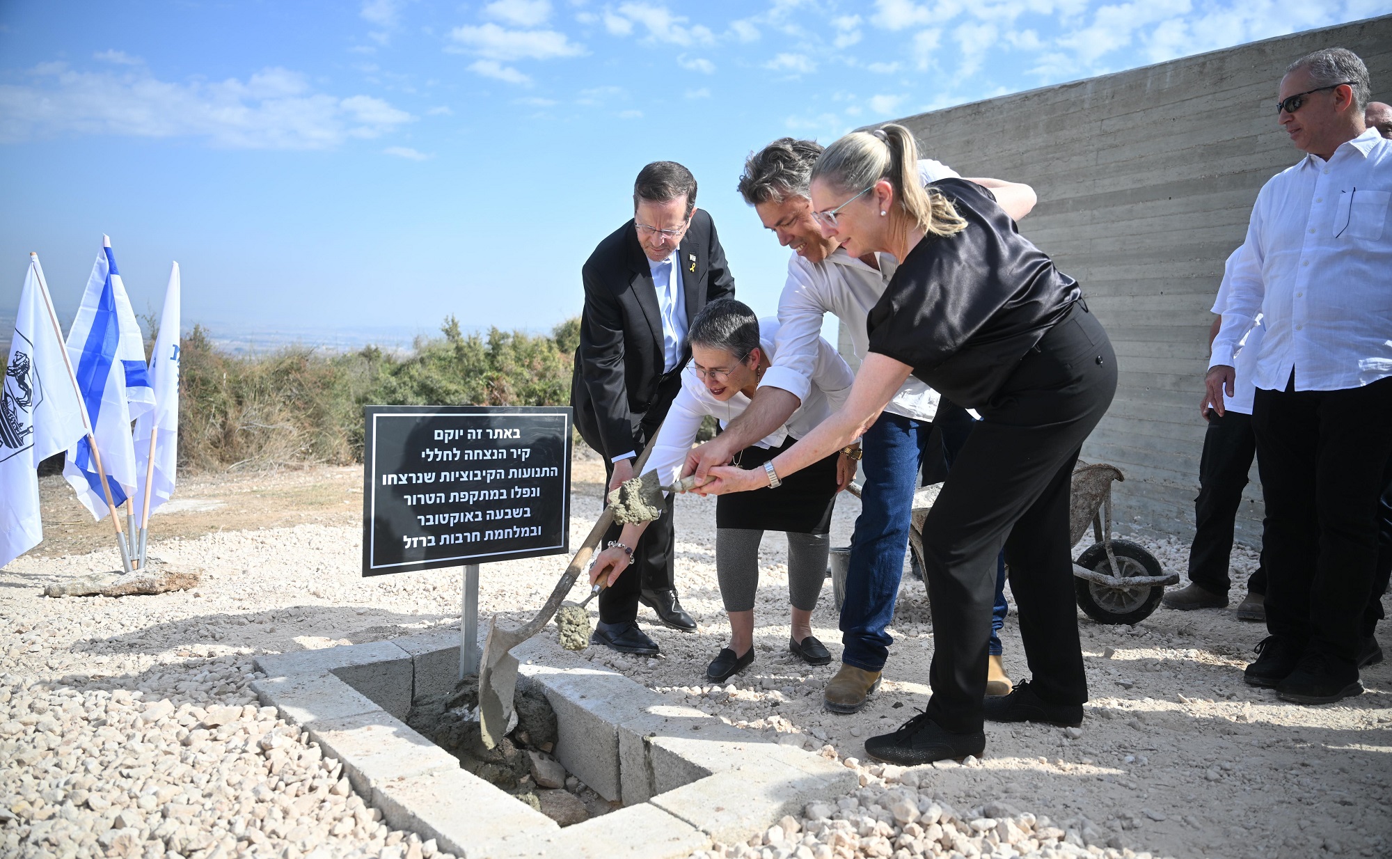 נשיא המדינה יצחק הרצוג ורעייתו מיכל מניחים את אבן הפינה לקיר ההנצחה יחד עם מזכ"לי התנועות הקיבוציות. צילום: אלעד גוטמן